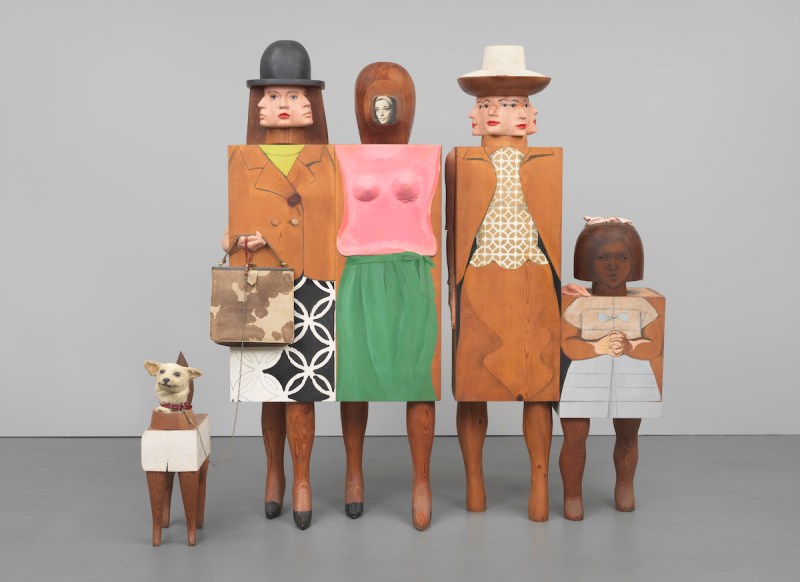 一个雕塑，展示了几个抽象的女人和一个孩子，以及一只狗。每个人物的身体都被抽象成一个立方体，上面画着他们的衣服。他们的脸高度风格化，有些看起来有多个头。